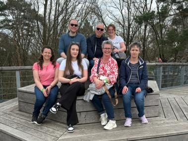 Gruppenbild des Teams auf einer runden Sitzmöglichkeit