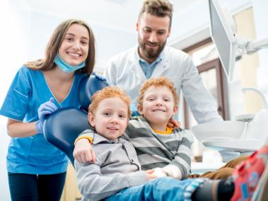 Zwillinge mit Mutter beim Zahnarzt