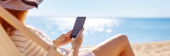 Frau mit Handy am Meer
