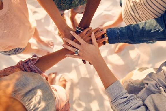 Team hält Hände in der Mitte zusammen