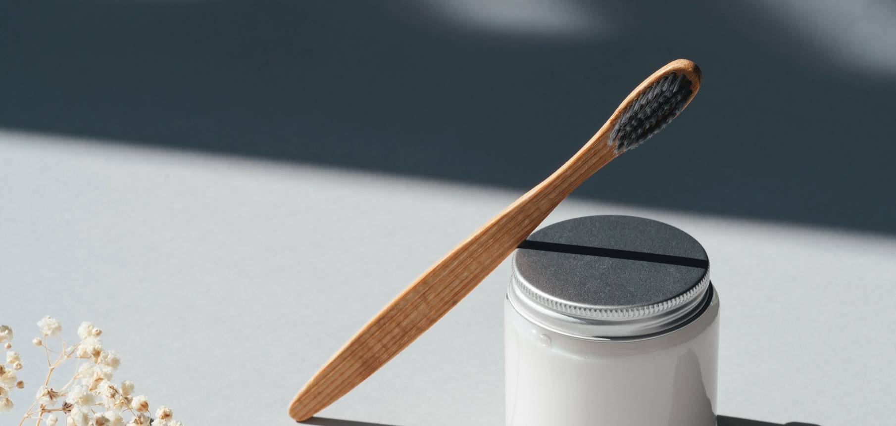 Zahnbürste lehnt an Zahnpastadose