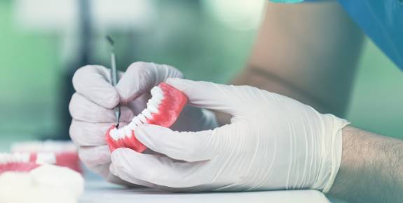 Zahntechniker arbeitet an Gebiss im Labor