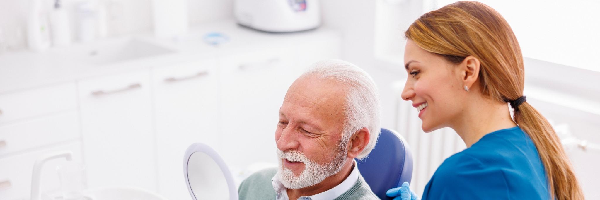 Zahnärztin mit älterem Patienten